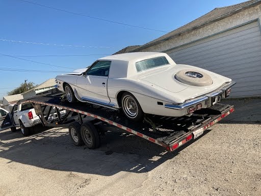 white classic cadillac on open trailer