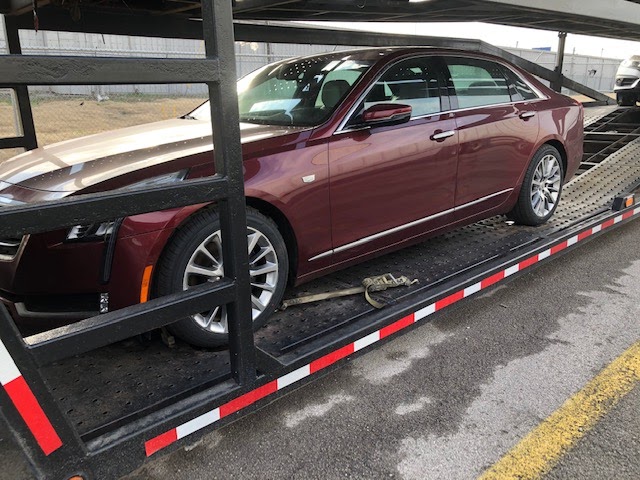 red cadillac on open trailer