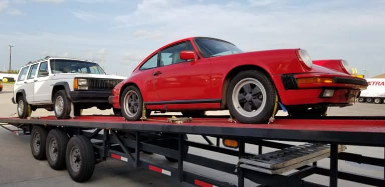 vintage red porsche 911 on diagonal trailer for auto transport