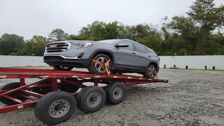 GMC vehicle being transported on an open trailer