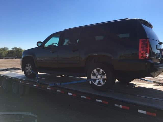 black gmc yukon on flatbed trailer