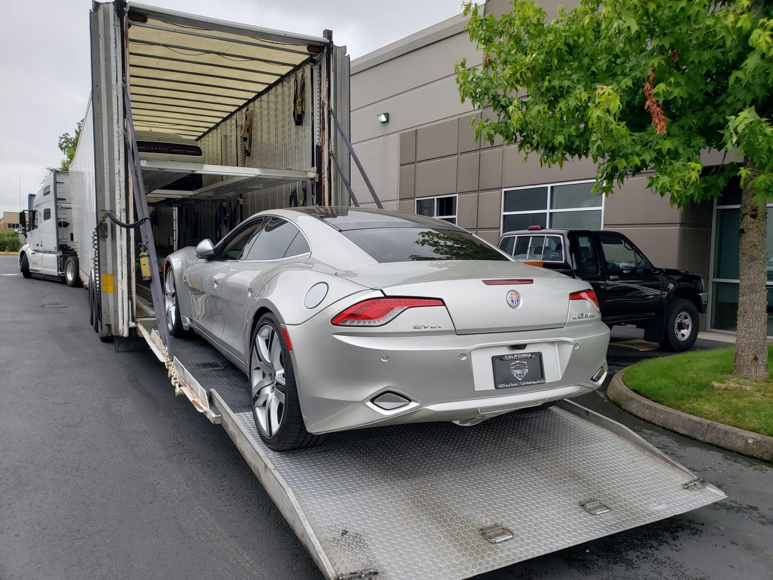 silver fisker karma going into elevated trailer for auto transport