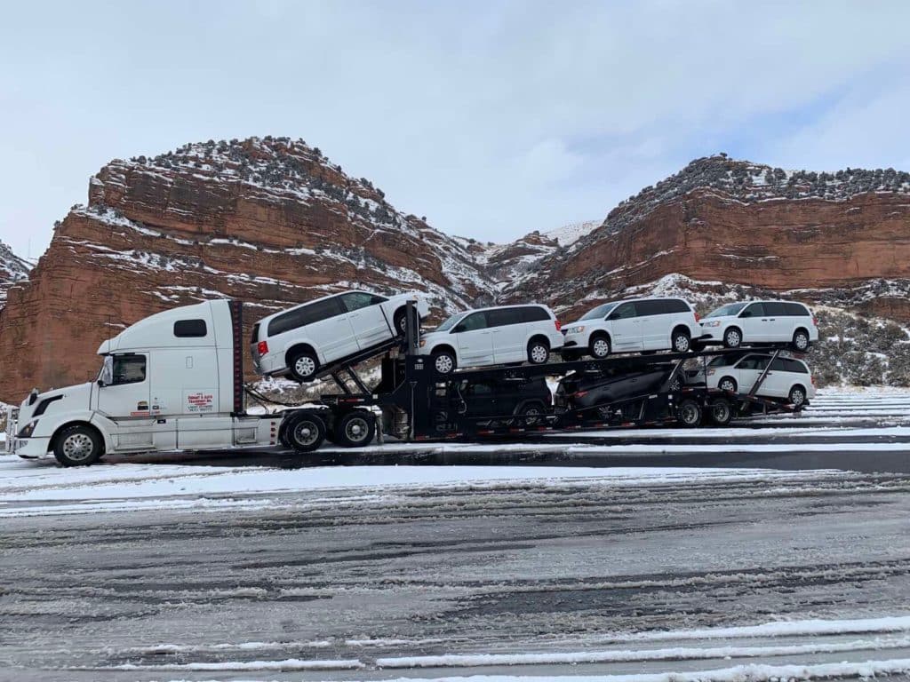 mulitple mobility vans on open trailer