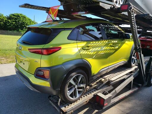 green hyundai on open trailer