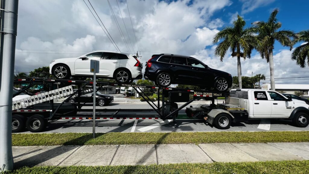 two volvo vehicles being transported on an open trailer