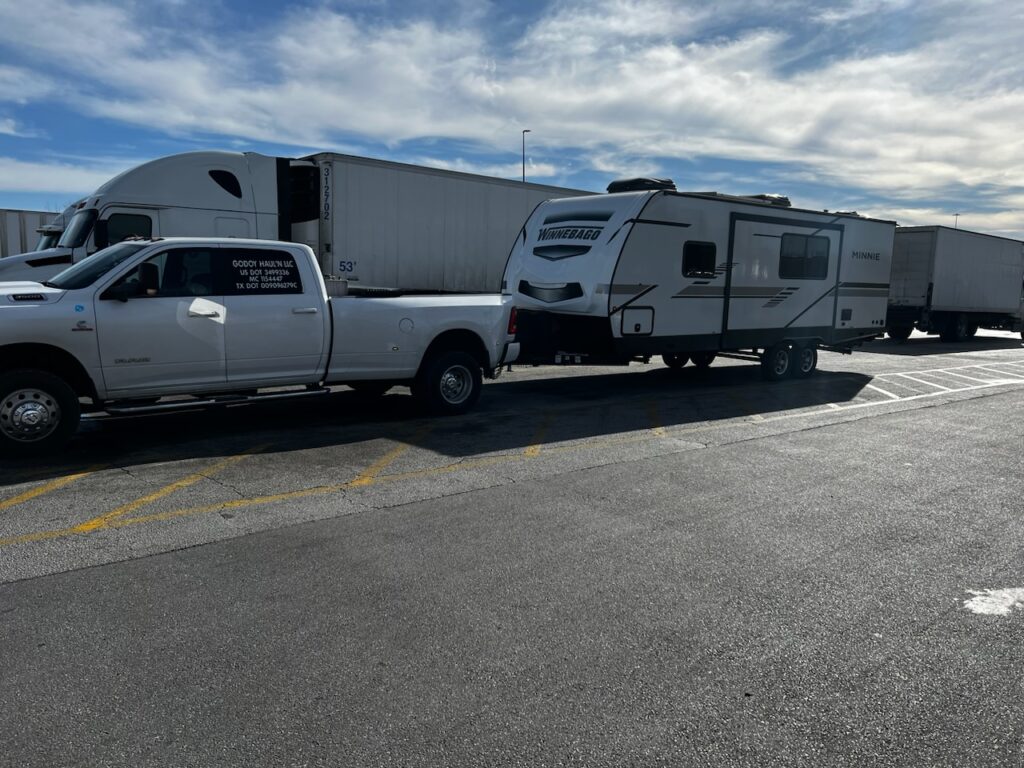 Rv being pulled by a white truck