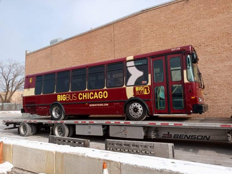 red public bus being transported
