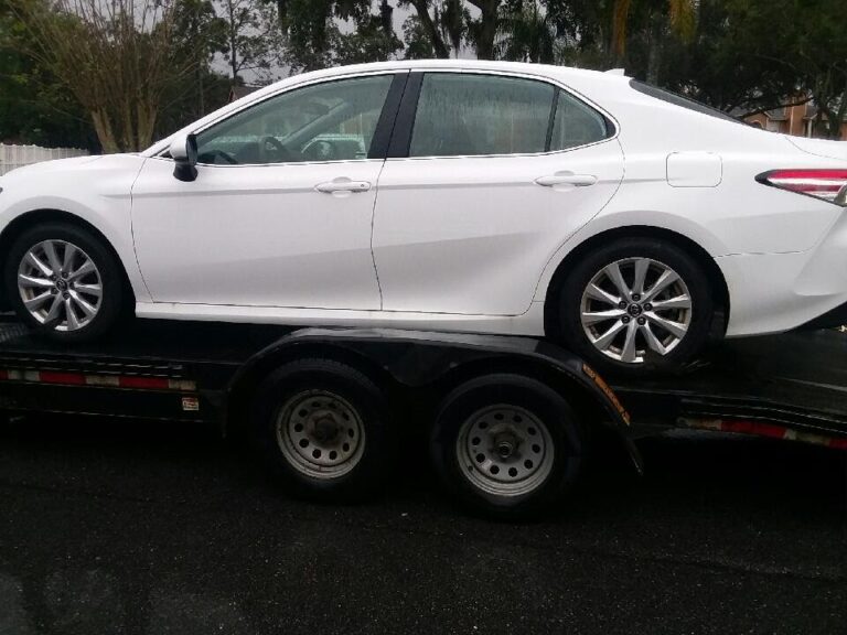 white Toyota camry on open trailer