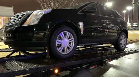 black cadillac on open trailer