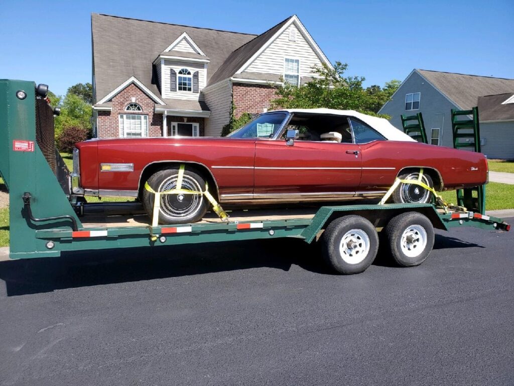 red 1976 el dorado classic on trailer for auto transport