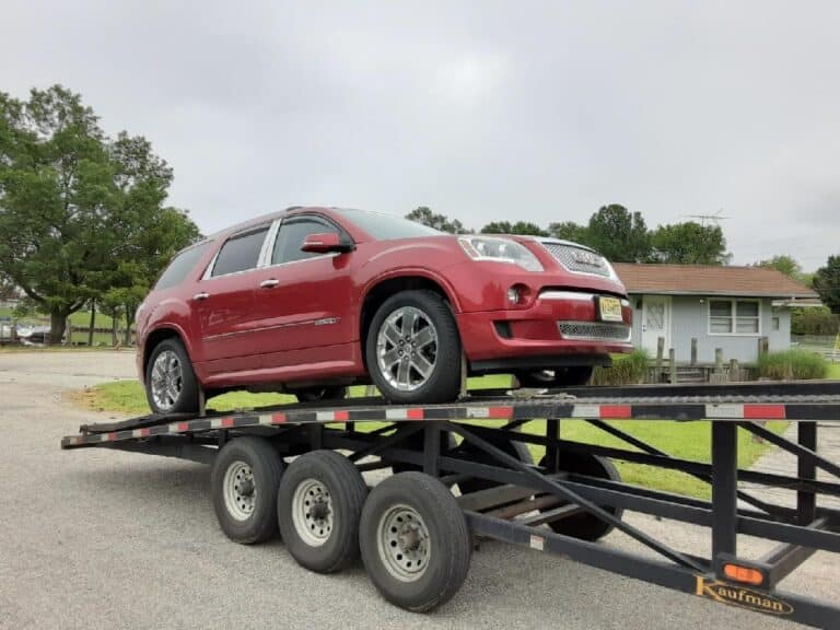 red GMC suv on open trailer
