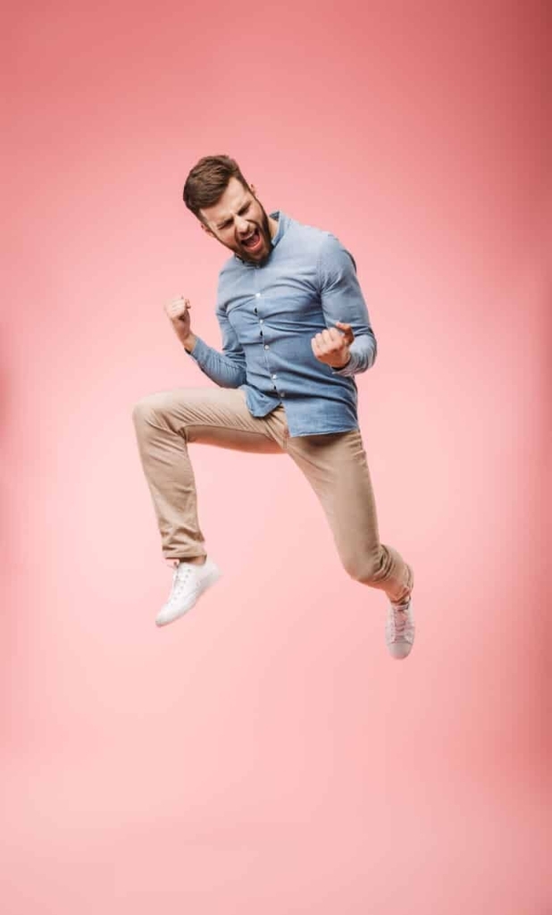 Un joven saltando en el aire por su transporte de auto rapido y feliz