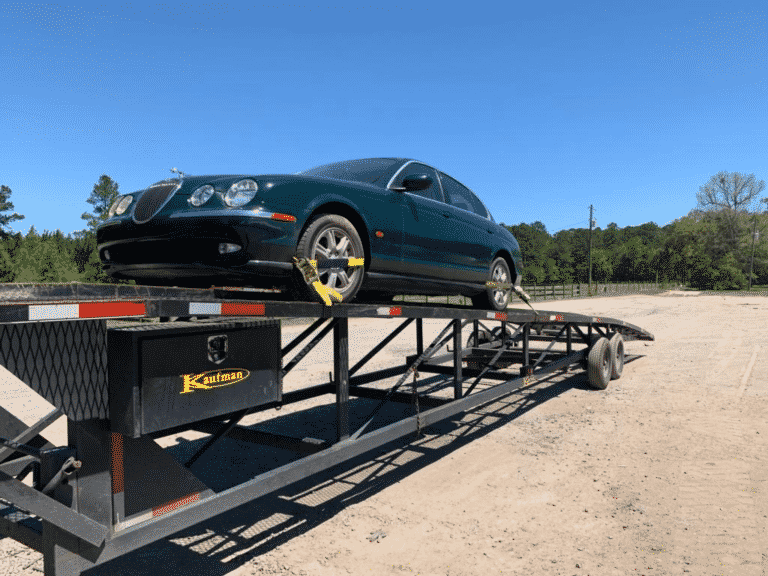 green jaguar on open trailer