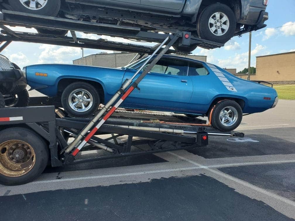 blue classic car on open trailer
