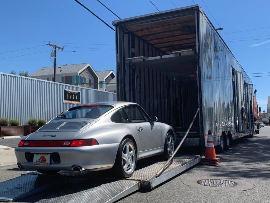 silver carrera porsche in enclosed trailer for auto transport