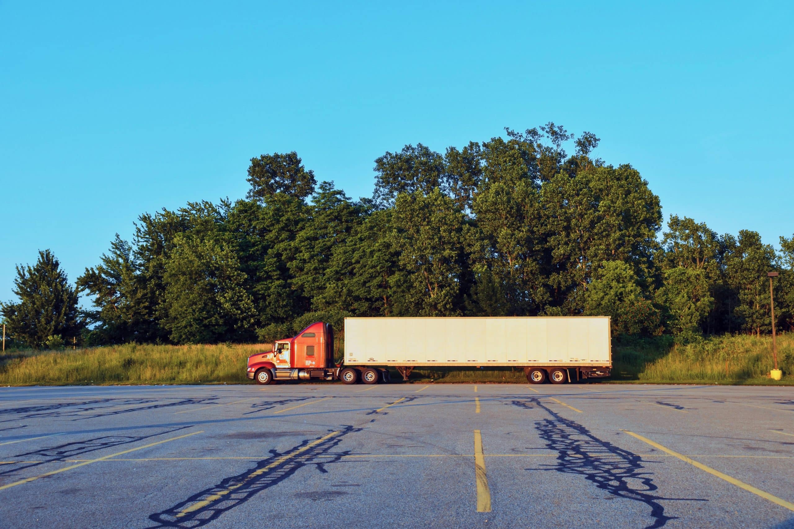 red cab enclosed transport trailer for auto transport in parking lot