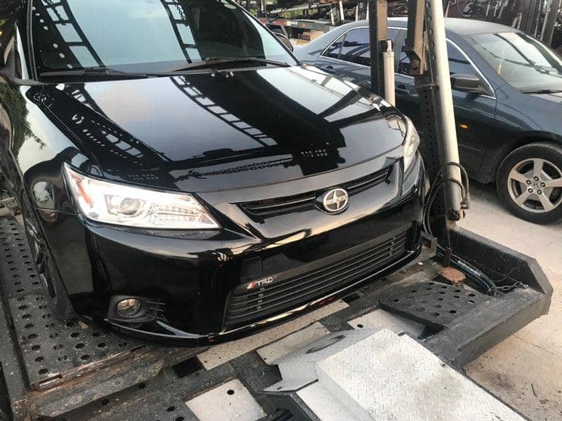 Black Scion car on a truck.