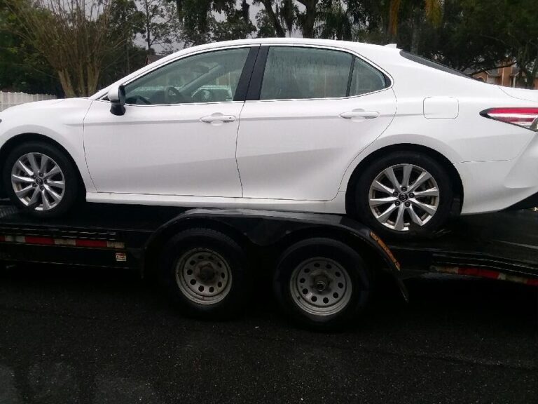white Toyota camry on open trailer