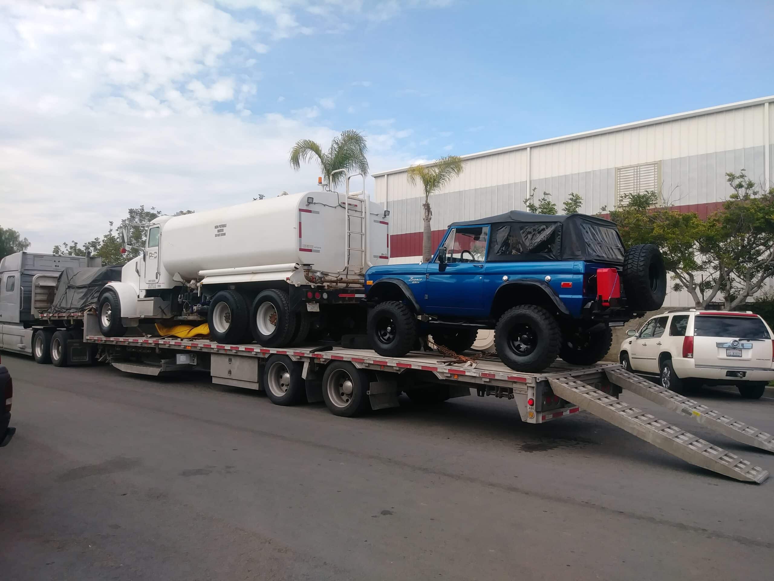 ford vehicle and heavy truck on flatbed trailer