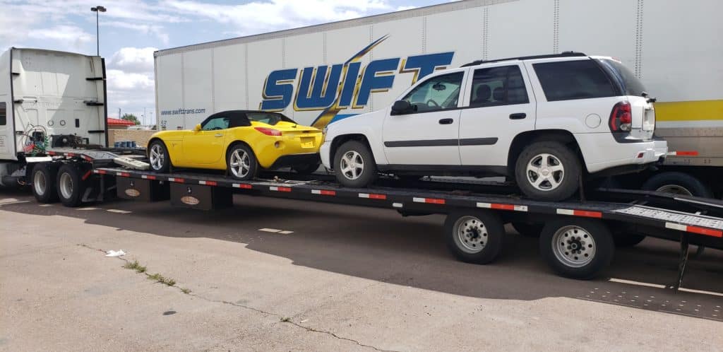 two cars loaded and ready to be transported