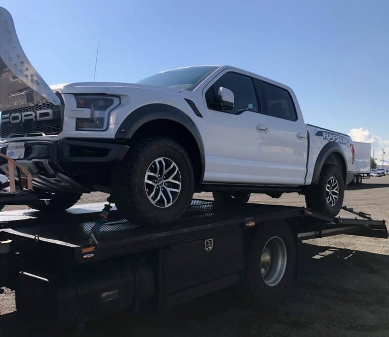 white ford raptor on small trailer