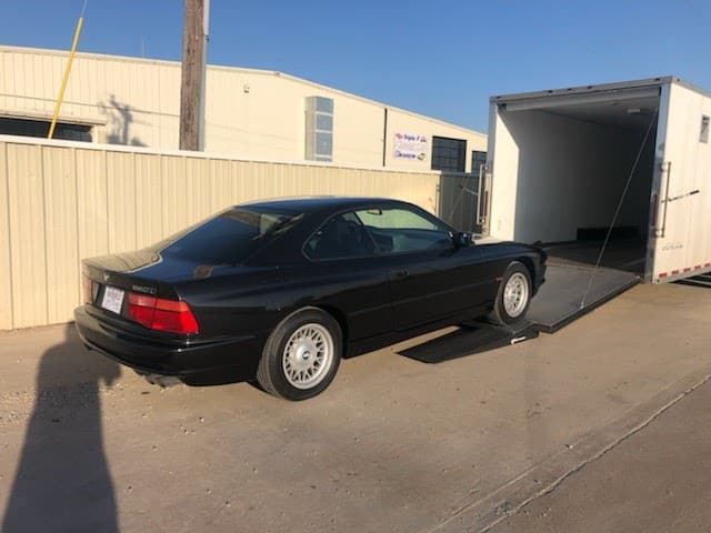black classic bmw loading in closed trailer