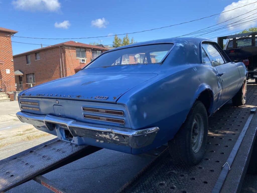 blue classic pontiac on trailer