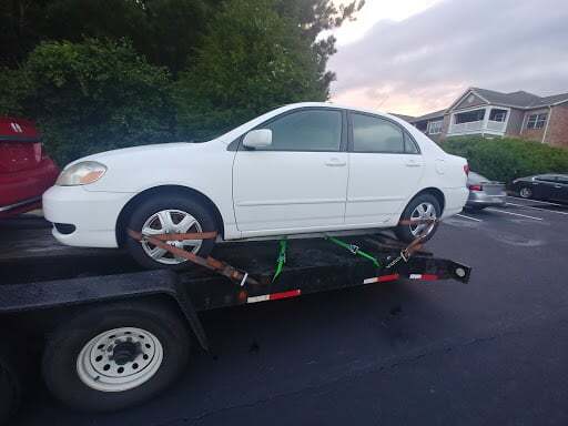 white toyota on open trailer