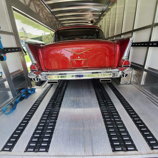 red chevy bel air being transported in a closed trailer