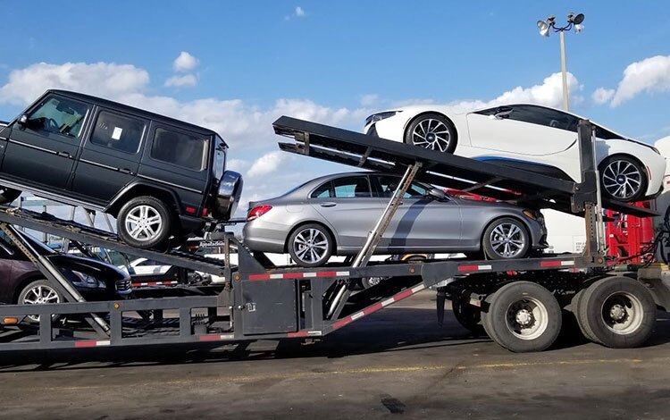 Open car trailer moving multiple cars across country
