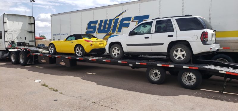 two cars loaded and ready to be transported
