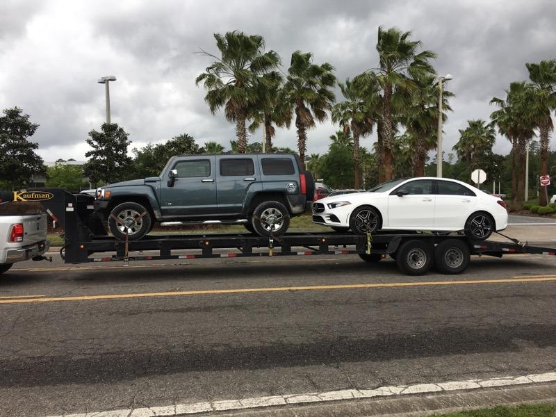 tow vehicles on step deck trailer for auto transport