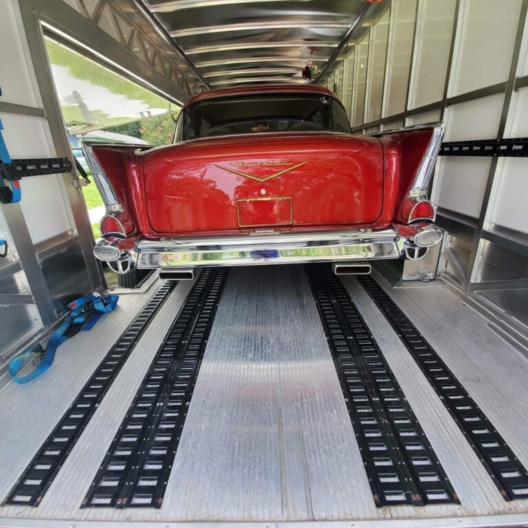 red classic car in enclosed trailer
