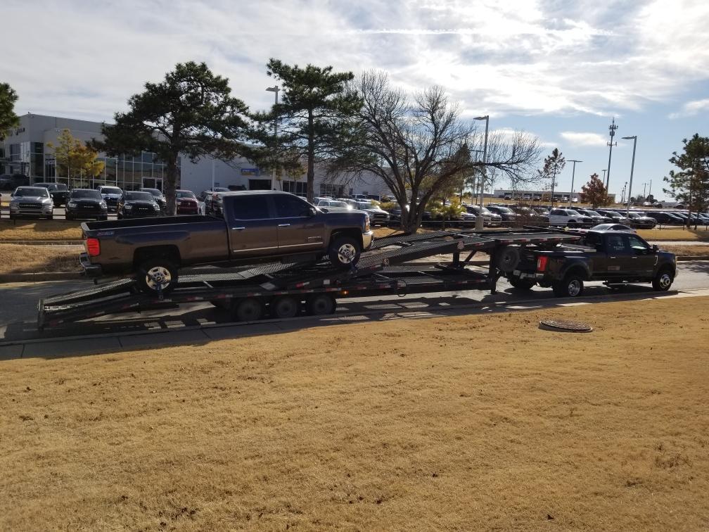 black dodge truck on auto transport trailer