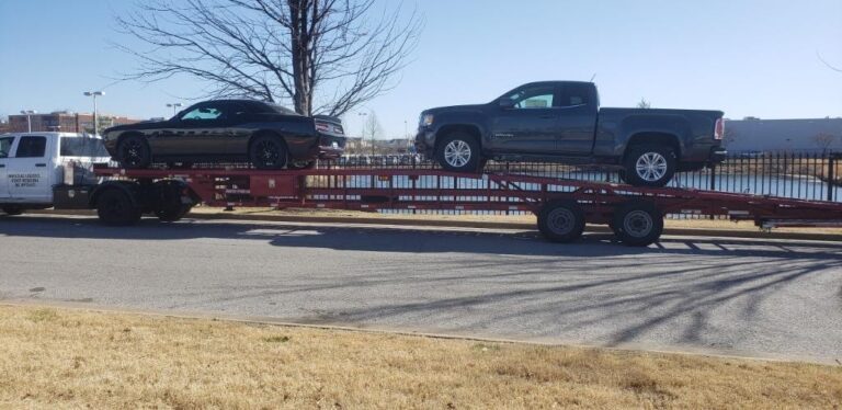 GMC truck and dodge challenger on open trailer