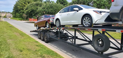 multiple vehicles on small open trailer