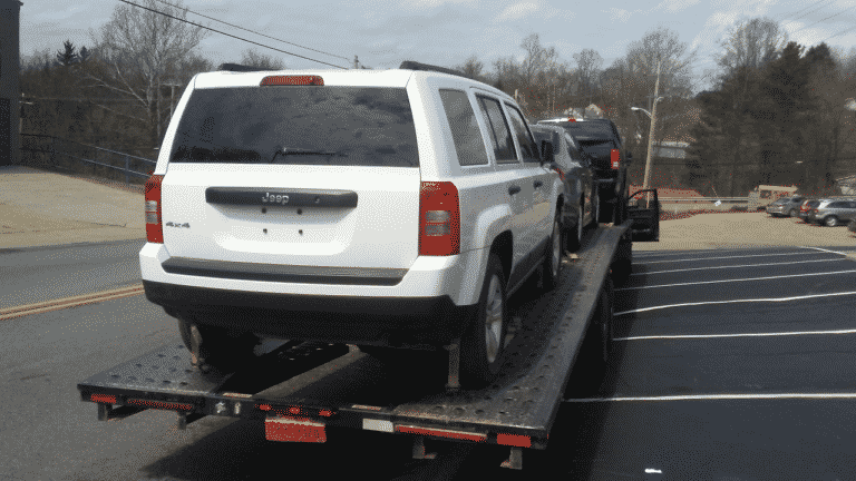 white jeep on open trailer
