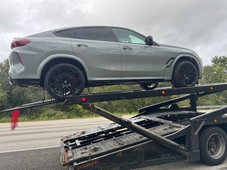 bmw x6 on an open carrier being transported