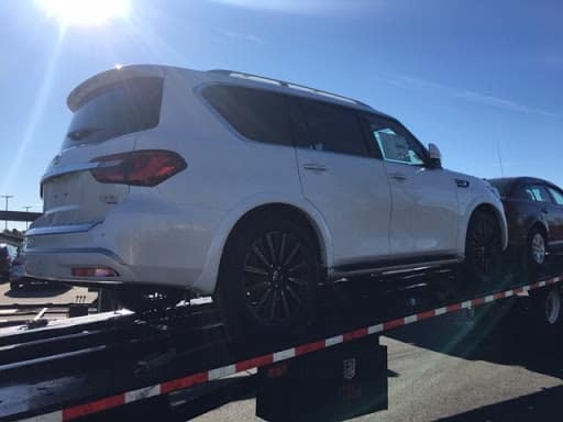 white infiniti QX80 on trailer