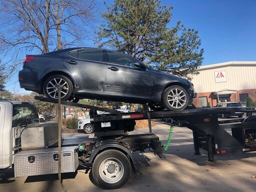 grey crashed car on trailer