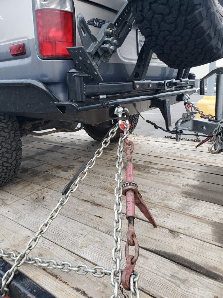 car safely and secured tied down on transport trailer