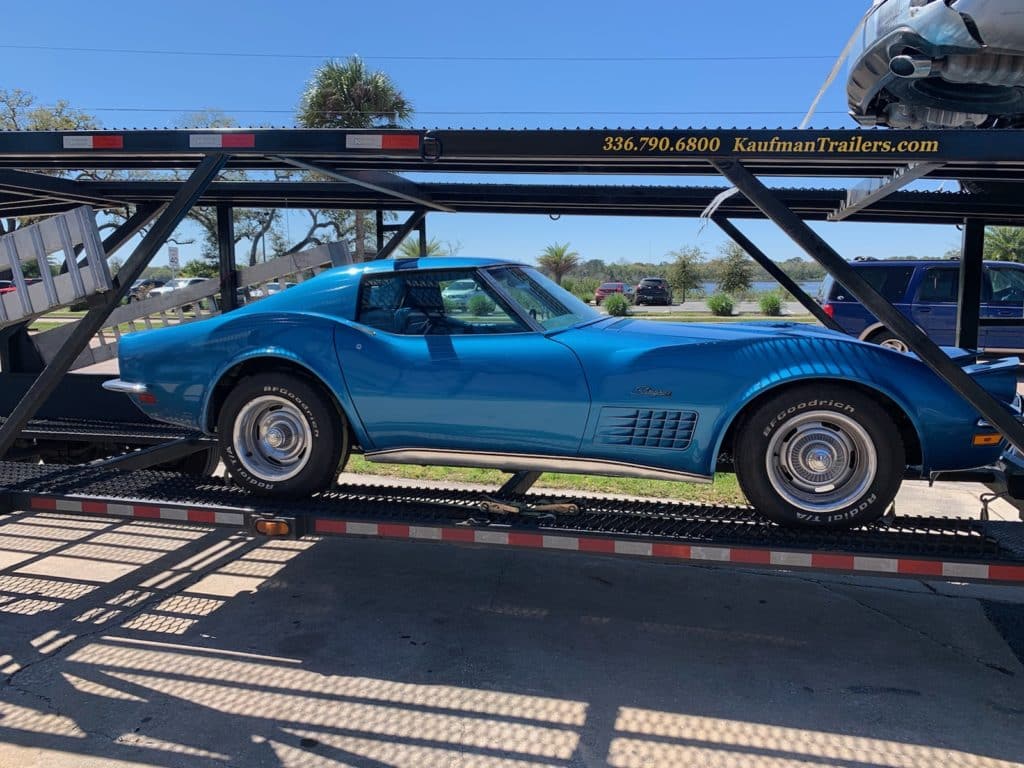 bright blue vintage corvette on trailer for auto transport