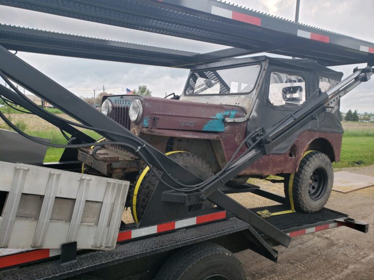 vintage jeep on stepdeck trailer for auto transport