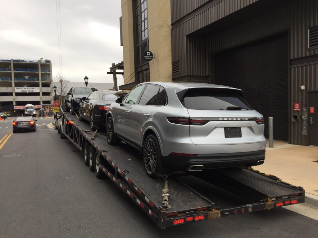 silver porsche suv on trailer for auto transport