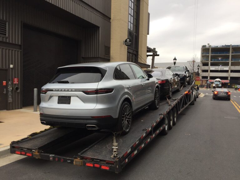 silver porsche suv on trailer for auto transport