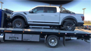 white ford raptor truck on car shipping trailer