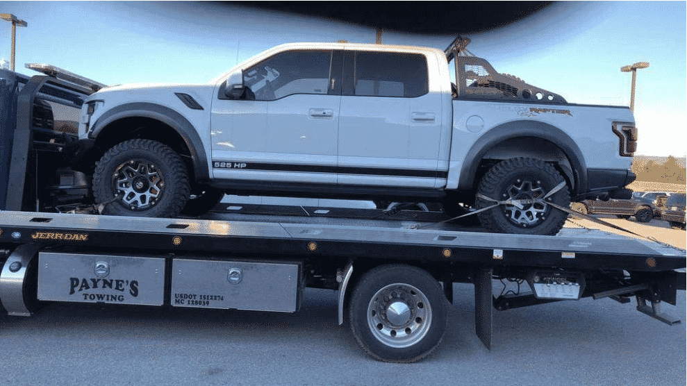 white ford raptor truck on car shipping trailer