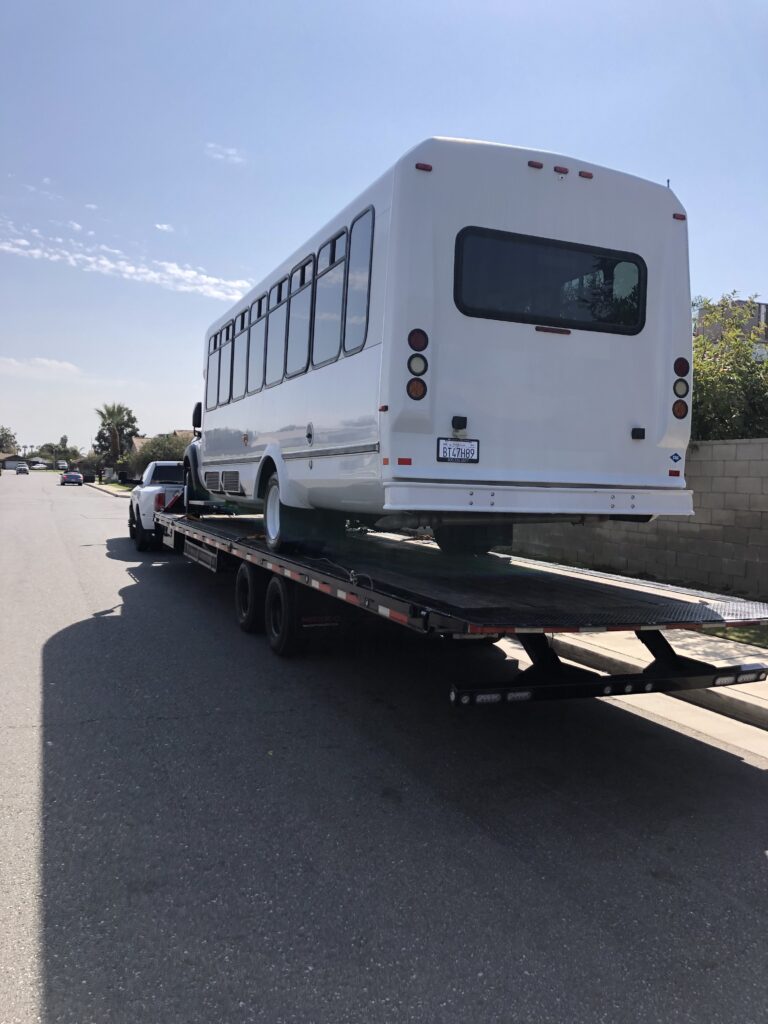 white shuttle bus being transported