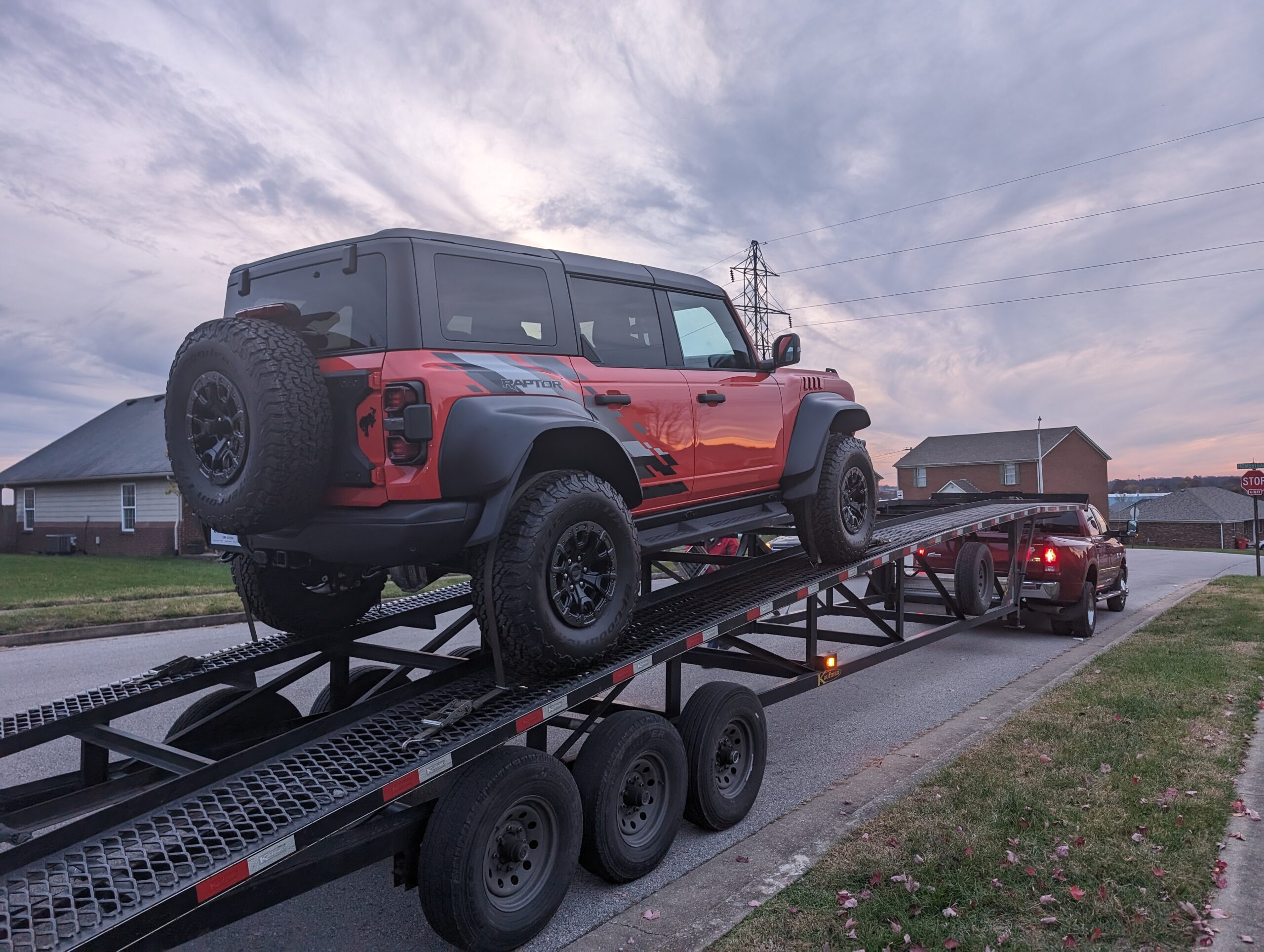 red ford raptor on open carrier