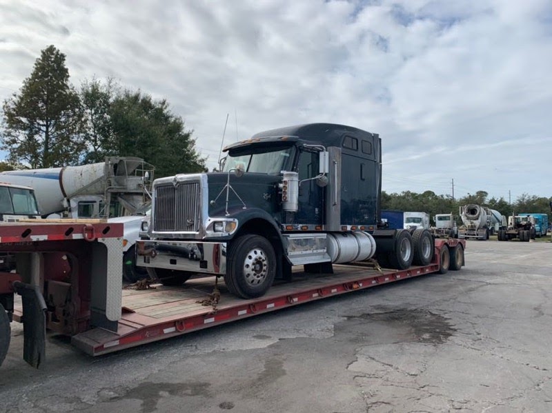 semi truck on trailer being transported across the country